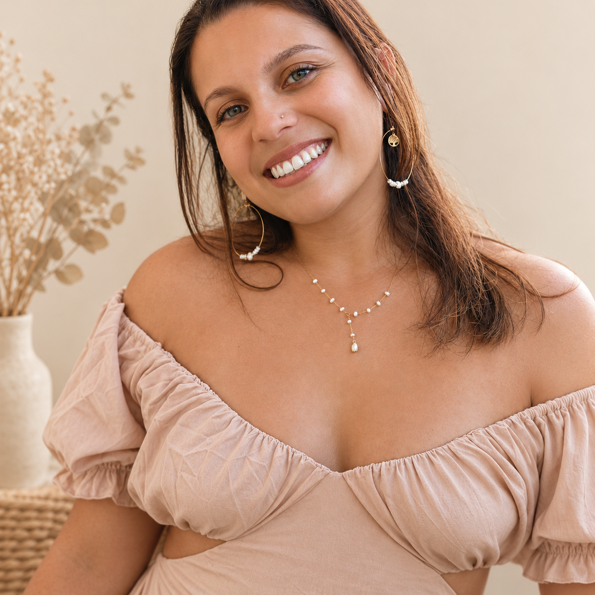 Esa, créatrice de bijoux en acier inoxydable faits main, portant un collier et des boucles d'oreilles perles d'eau douce